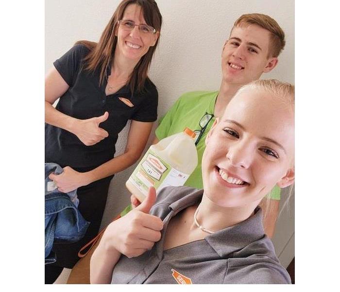 Three members of our cleaning crew smiling as they get ready to start a job